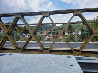 Blick von der Ersatzfußgängerbrücke, durch die Ersatzbrücke für Fahrzeuge, auf die sehr aktive Baustelle der Uferinstandsetzung/Erneuerung.